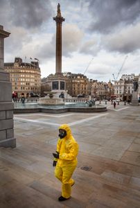 Man In HAZMAT suit Crossing A Deserted Trafalgar Square  As The Coronovirus Clampdown Begins. London Lockdown, 2020