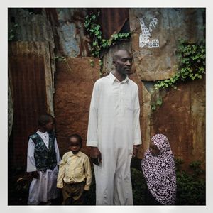 A Somali refugee family stand next to their corrugated iron house in Kibera. The Kibera slum is the largest slum in Nairobi with around half a million inhabitants.