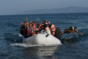 Syrian refugees make the victory sign after making the five mile crossing from Turkey to Greece. Thousands were landing every day on Lesvos island pushing to its limit the authorities' capability to process them.