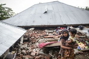 Survivor, Nilawati M. Daud, 30 years old, with her daughter, Maiza, 2 years old, visit her house were destroyed following the earthquake in Pidie Jaya, Aceh province, on December 10, 2016.