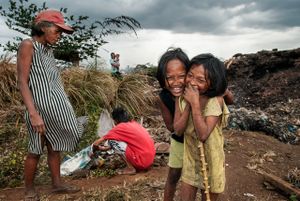 Children manage to playfully pose for a shot despite the dismal condition on Smokey Mountain.