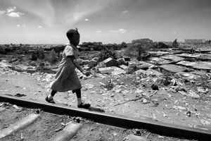 © Tony Corocher - Africa, where are you going? - A young girl playing on the railway that runs through Kibera (the second largest slum in the world). All you can see in the background is Kibera with over one million people… while I was taking this picture my mind kept thinking about what kind of future awaits the African countries.