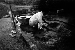 Sintku Township, Mandalay Division, Myanmar, 2013. A gold miner pans crushed ore to separate gold flakes from the rest of the stone. Workers collect the residue from the machine process, panning it at home, to make a little extra profit. © Spike Johnson