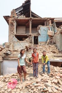 Siblings Saraswati (11) and twins Yamuna and Jamuna (8) stand on the rubble outside the remains of their family home. The children were outside their home in Bhaktapur when the earthquake struck on 29th April, 2015. Whilst they all survived, their family home was destroyed, leaving them to take shelter beneath tarpaulins erected outside.