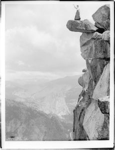 Woman (Miss Loomis?) standing on the precarious Glacier Point