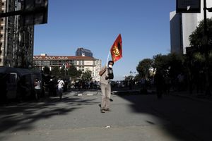 A protester with a broken arm in a the splint holding the flag of a left political party in front of a makeshift barricade near Gezi park in Istanbul, Turkey on Tuesday, June 11, 2013.