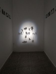 Drifting…, installation, 2016, variable dimension10 giclée prints 10 x 15 cm on aluminium, white curtain, shadow installation, cardboard silhouettes, wooden sticks, projector