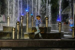 Boy plays next to fountain