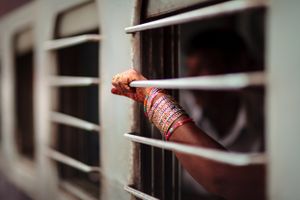 The arm and hand of a passenger on a train at New Delhi Train Station in India