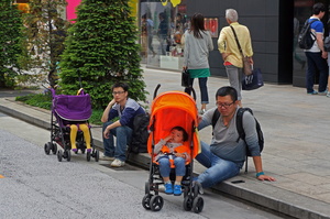 two pairs of Chinese father and stroller with infant on board