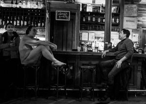 Nude man at a bar