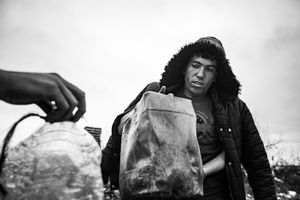 A people collect water in makeshift shelter near main train station  in Belgrade, Serbia.