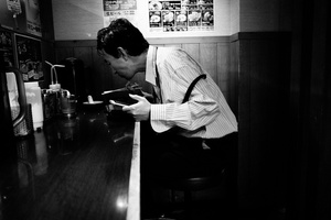 A man eats alone his ramen in a shop in Shinjuku