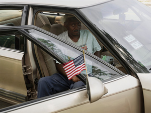 USA. Chicago. 2015.  Lonely man in a car with an America flag.