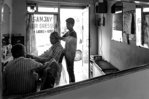 The Barber - Sanjay chats with a regular customer while Sanjay's understudy Sameer gives the man a head massage.