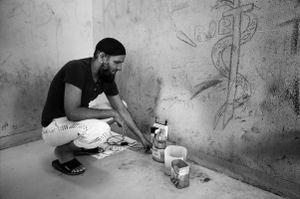 A migrant shows how detainees prepare coffee or tea, heating water through electric wires in a cutted plastic bottle. Bari Palese.
