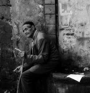 Man with cigarette and stick.