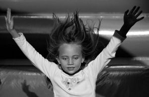 Girl hurtles herself down giant, inflatable slide, Kyiv's Schevchenko Park summer day.
