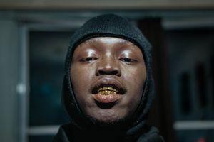 At his friends house, showing off his new “Grillz” (fake golden tooth).