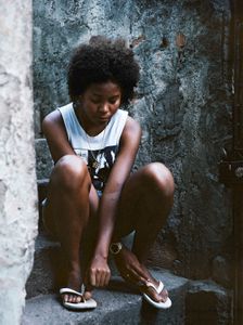 Thay sitting in her street in  favela Vila Cruzeiro.