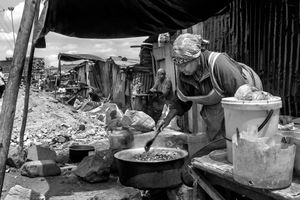 © Tony Corocher - High quality, protein soup ready... This woman is preparing a basic meal which will be sold to the people walking by... most people (especially women) always find something to do to make a living. There are many women like this one, cooking or doing some other kind of activity on the streets of Mathare, kibera and in all the other slums in Nairobi.