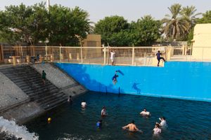 Kids jump from a high spot in the pool