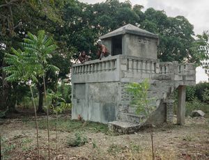 Thomas Bressier (42) et Delima Bressier (33) - Aquin, Haiti - Qui repose dans ce tombeau? Mon père, ma grand-mère et ma tante - Pourquoi aimez vous aller sur cette tombe? "Quand il y a beaucoup de chaleur, on aime se poser là-haut" - Qui a dessiné ce monument? Boss Solide (maçon de la famille) fin 2010