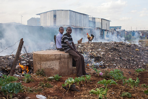 Sinai slum, Nairobi, KENYA, 29.10.2013: Teachers from Jobenpha community school sit down next to the schools yard during lunch break.